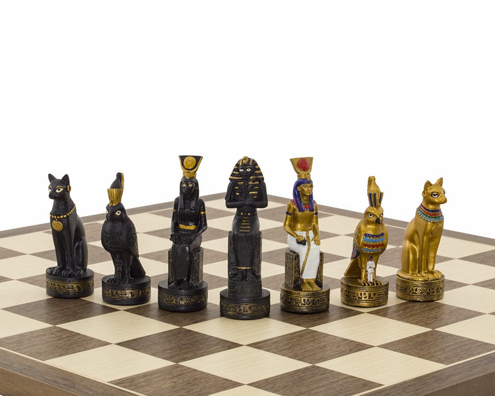 Ancient Egypt hand-painted themed chess pieces by Italfama on a chessboard, featuring ornately detailed black and gold figures.