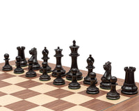 1851 Reproduction Staunton Ebony Chessmen arranged on a chessboard, featuring a 4.4-inch king and broad 2-inch bases.