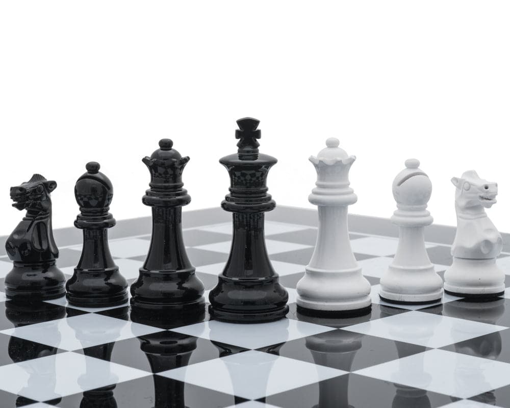 Monochrome luxury chessmen by Italfama on a green and gold leatherette chessboard with backgammon on reverse