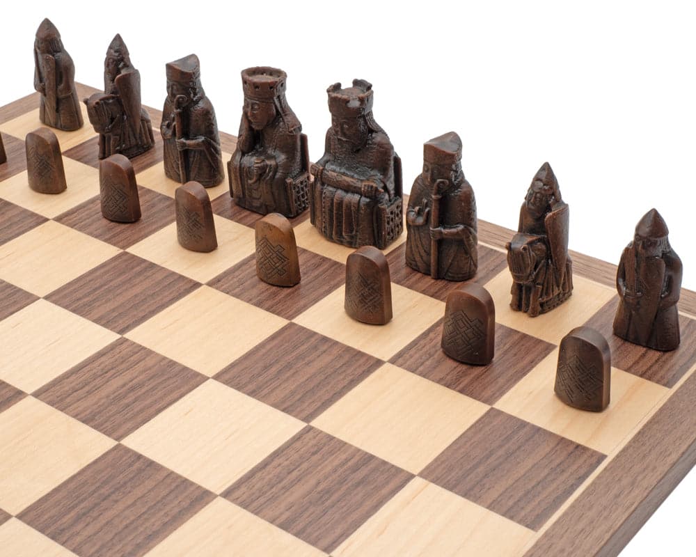 Close-up of Isle of Lewis Chessmen on a wooden chess board, showcasing detailed and intricately crafted pieces in a classic design.